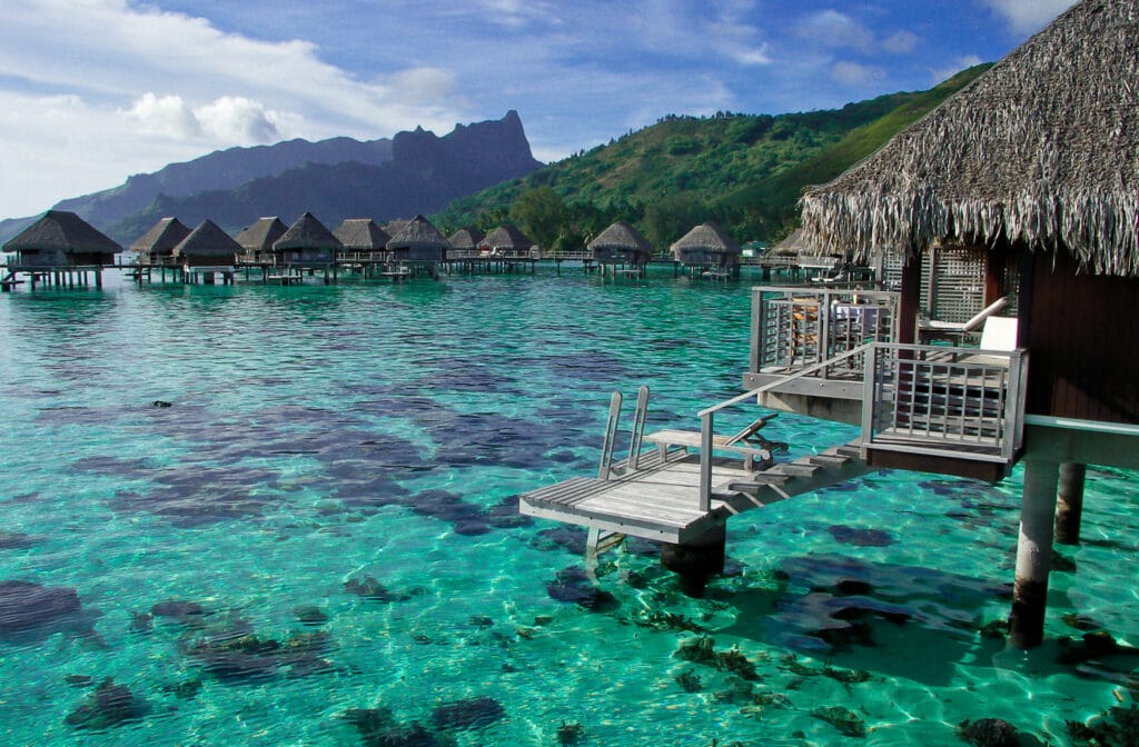 Bora Bora bungalows over the water with amazing views of the ocean and sky in the background